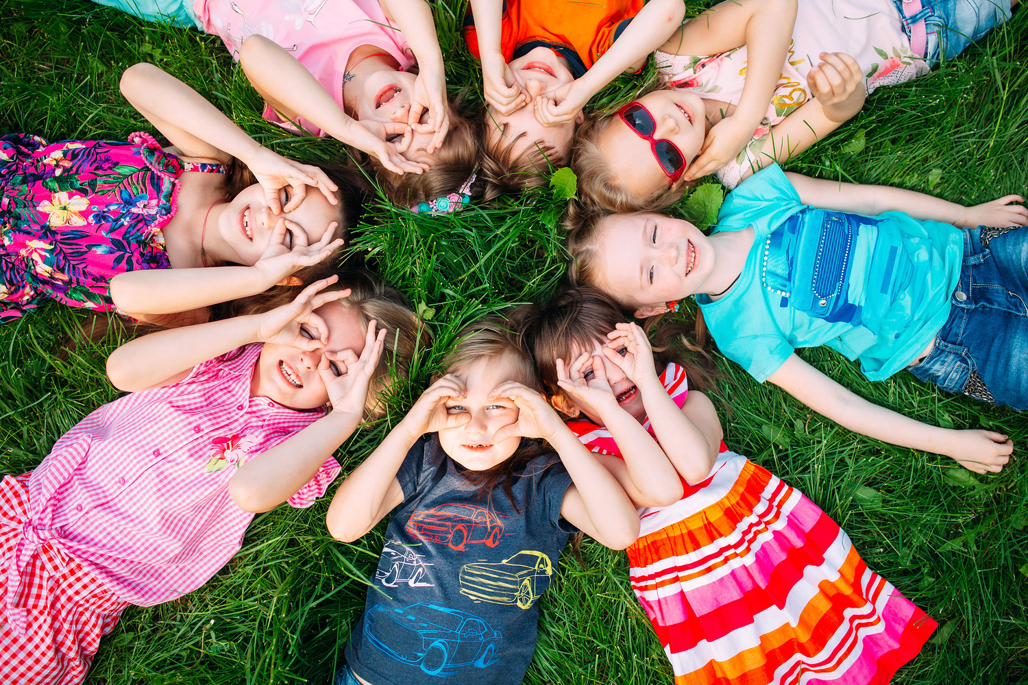 A group of children lying on the green grass in the Park. The interaction of the children